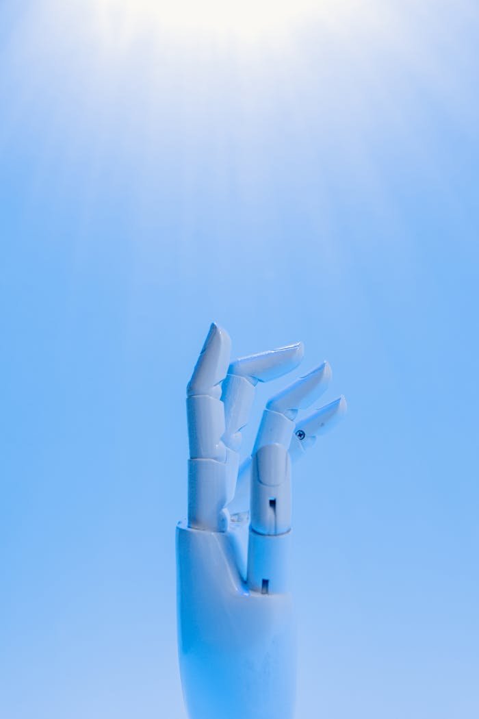 services-04 A robotic hand reaching upward against a blue sky, symbolizing technologys future.